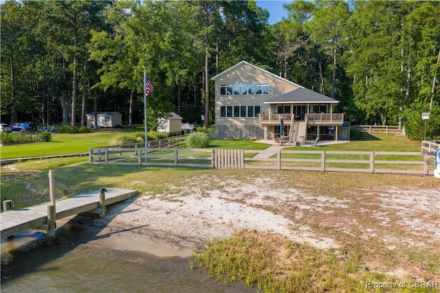 11 Franklin St, Deltaville, VA 23043 - view of front of property featuring a deck with water view, a fenced backyard, and a shed
