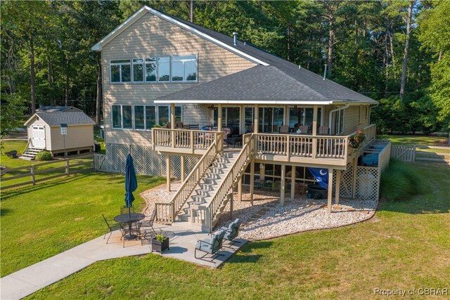 11 Franklin St, Deltaville, VA 23043 - back of property with stairway, a shingled roof, a wooden deck, a patio, and an outbuilding