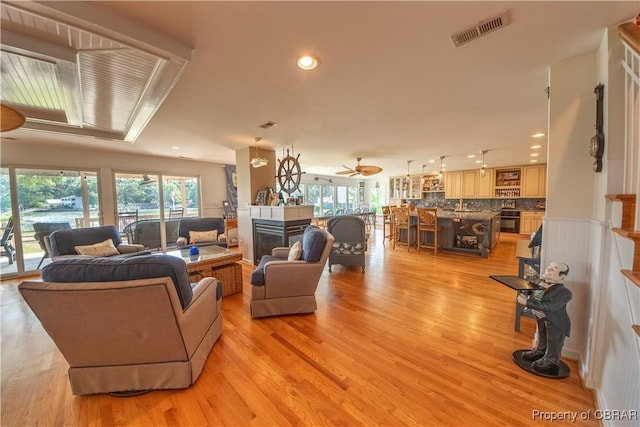 11 Franklin St, Deltaville, VA 23043 - living area with a multi sided fireplace, light wood-style flooring, recessed lighting, and a ceiling fan