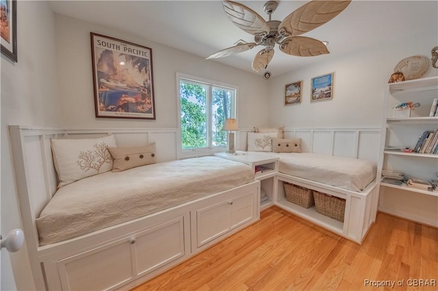 11 Franklin St, Deltaville, VA 23043 - bedroom with wainscoting, light wood finished floors, a decorative wall, and ceiling fan