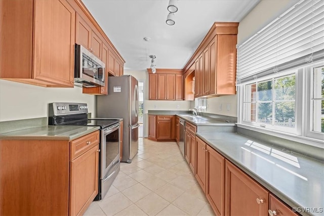 3000 W Riverside Ave, Hopewell, VA 23860 - kitchen with stainless steel appliances, light tile patterned flooring, brown cabinetry, and light countertops