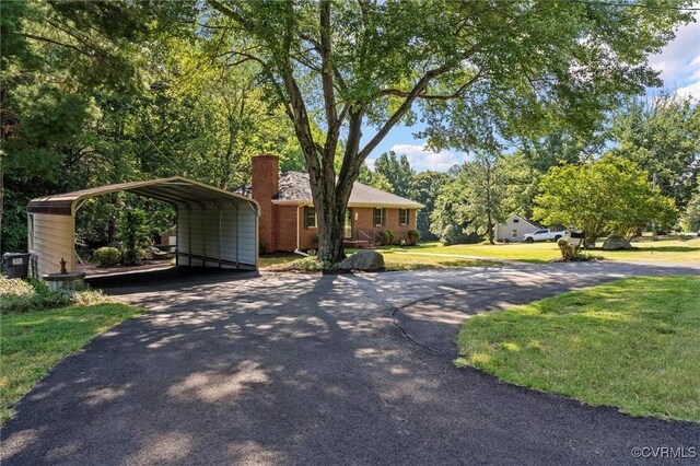 2001 Hicks Rd, North Chesterfield, VA 23235 - view of front of house featuring driveway, a detached carport, a front lawn, and a chimney