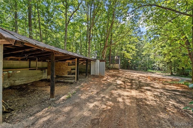 2001 Hicks Rd, North Chesterfield, VA 23235 - view of yard featuring an outdoor structure, a view of trees, a carport, and driveway