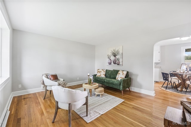 4308 Sunset Dr, North Dinwiddie, VA 23803 - living room featuring arched walkways, light wood-type flooring, and a baseboard radiator