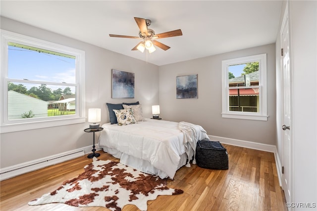4308 Sunset Dr, North Dinwiddie, VA 23803 - bedroom featuring a baseboard heating unit, wood finished floors, and a ceiling fan