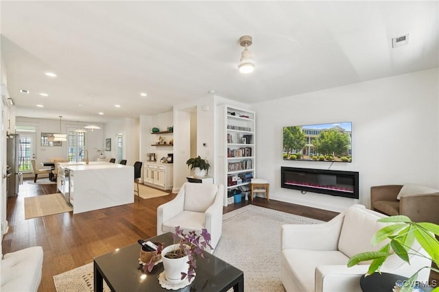 14424 Michaux Village Dr, Midlothian, VA 23113 - living area featuring a glass covered fireplace, dark wood-style floors, and recessed lighting