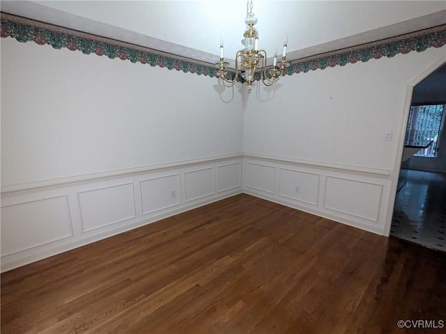 12703 Colby Cove Ct, Chester, VA 23831 - empty room with a chandelier, dark wood finished floors, a wainscoted wall, and a decorative wall