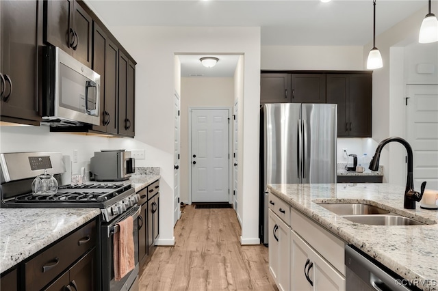 18325 Palisades Ct, Moseley, VA 23120 - kitchen with stainless steel appliances, light wood-style flooring, light stone countertops, pendant lighting, and dark brown cabinets