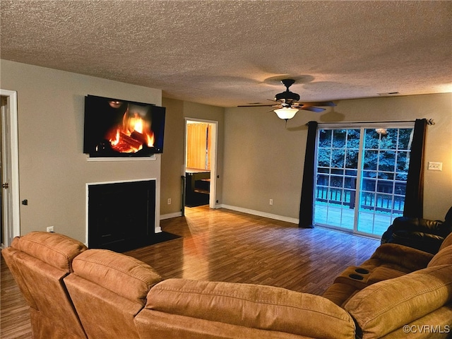 4740 Old Williamsburg Rd, Sandston, VA 23150 - living area featuring wood finished floors, a ceiling fan, a fireplace with flush hearth, and a textured ceiling