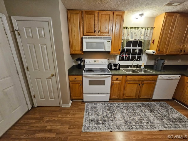 4740 Old Williamsburg Rd, Sandston, VA 23150 - kitchen with white appliances, dark countertops, brown cabinets, and a textured ceiling