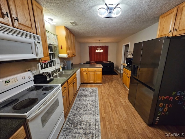 4740 Old Williamsburg Rd, Sandston, VA 23150 - kitchen featuring white appliances, a peninsula, light wood finished floors, dark countertops, and a textured ceiling