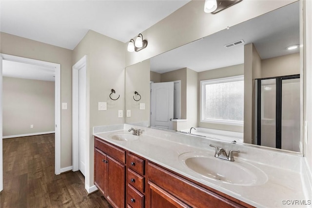17412 Trevino Pkwy, Moseley, VA 23120 - bathroom featuring double vanity, wood finished floors, a bath, and a shower with door