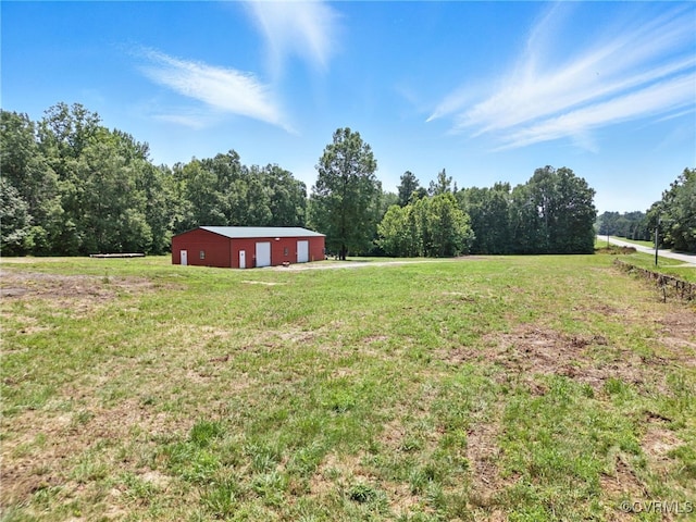 33419 Richmond Tpke, Hanover, VA 23069 - view of green lawn featuring a garage, a pole building, an outdoor structure, driveway, and a view of trees