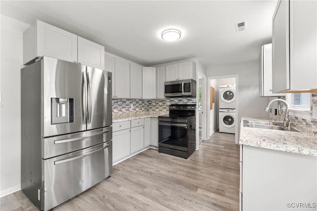 10500 Claybar Trl, North Chesterfield, VA 23236 - kitchen with stacked washer / drying machine, appliances with stainless steel finishes, backsplash, light wood-style flooring, and light stone counters