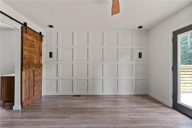 113 Rappa Run Rd, Topping, VA 23169 - unfurnished room featuring a barn door and wood finished floors