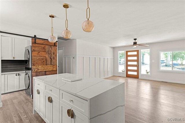 113 Rappa Run Rd, Topping, VA 23169 - kitchen featuring estacked washer and dryer, a center island, plenty of natural light, and light wood finished floors