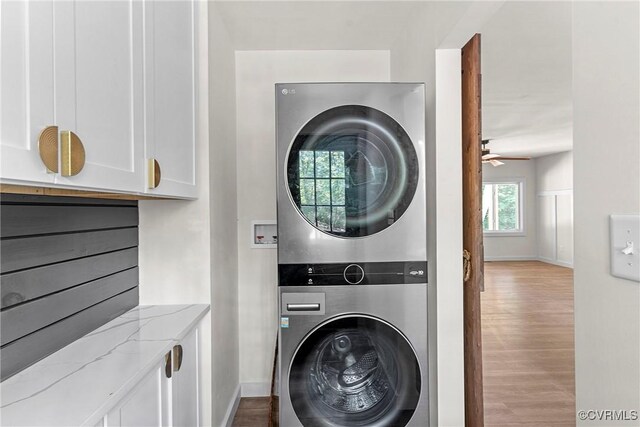 113 Rappa Run Rd, Topping, VA 23169 - laundry room featuring stacked washing machine and dryer, wood finished floors, a ceiling fan, and cabinet space