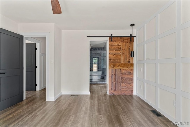 113 Rappa Run Rd, Topping, VA 23169 - empty room featuring wood finished floors, a barn door, and ceiling fan