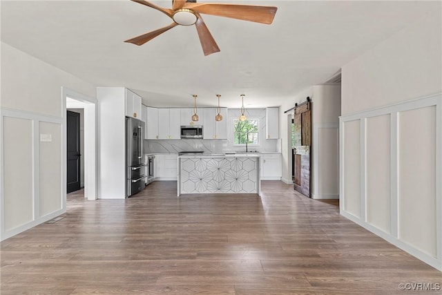 113 Rappa Run Rd, Topping, VA 23169 - kitchen featuring appliances with stainless steel finishes, ceiling fan, a barn door, light countertops, and white cabinets