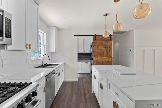 113 Rappa Run Rd, Topping, VA 23169 - kitchen with stainless steel appliances, decorative backsplash, a barn door, a kitchen island, and dark wood finished floors
