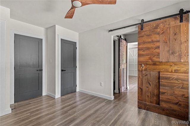 113 Rappa Run Rd, Topping, VA 23169 - spare room with a barn door, wood finished floors, and a ceiling fan