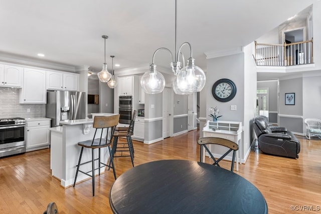 15585 Fox Cove Cir, Moseley, VA 23120 - kitchen featuring stainless steel appliances, a kitchen bar, white cabinetry, tasteful backsplash, and ornamental molding