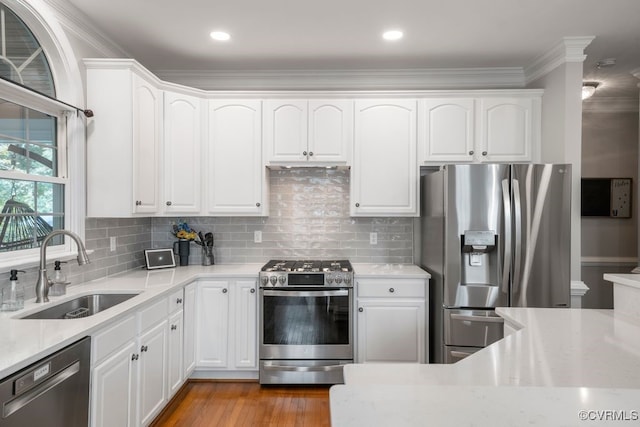 15585 Fox Cove Cir, Moseley, VA 23120 - kitchen featuring appliances with stainless steel finishes, ornamental molding, white cabinetry, tasteful backsplash, and wood finished floors