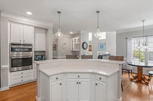 15585 Fox Cove Cir, Moseley, VA 23120 - kitchen with double oven, ornamental molding, light wood-type flooring, light countertops, and white cabinets