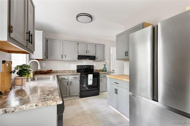 1712 Porters Mill Ln, Midlothian, VA 23114 - kitchen with freestanding refrigerator, black range with electric stovetop, under cabinet range hood, gray cabinetry, and light tile patterned flooring