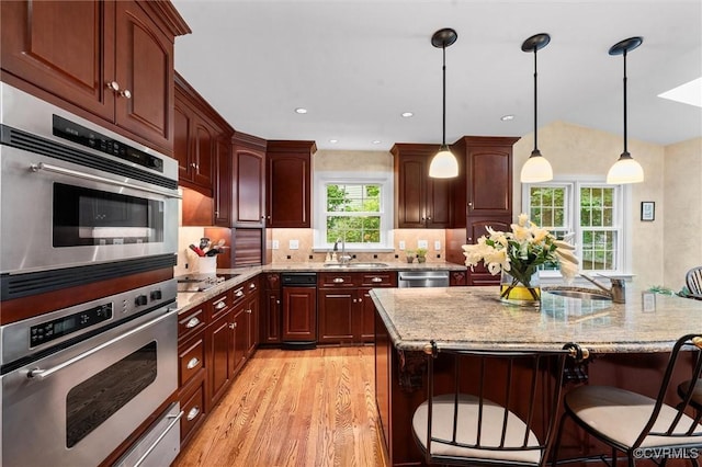 5911 Waters Edge Rd, Midlothian, VA 23112 - kitchen featuring light wood-style flooring, a breakfast bar area, light stone countertops, black electric stovetop, and pendant lighting