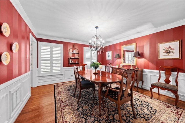 5911 Waters Edge Rd, Midlothian, VA 23112 - dining area featuring a chandelier, wood finished floors, crown molding, a wainscoted wall, and a decorative wall