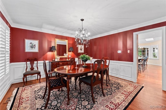 5911 Waters Edge Rd, Midlothian, VA 23112 - dining space featuring light wood-type flooring, a chandelier, ornamental molding, wainscoting, and a decorative wall
