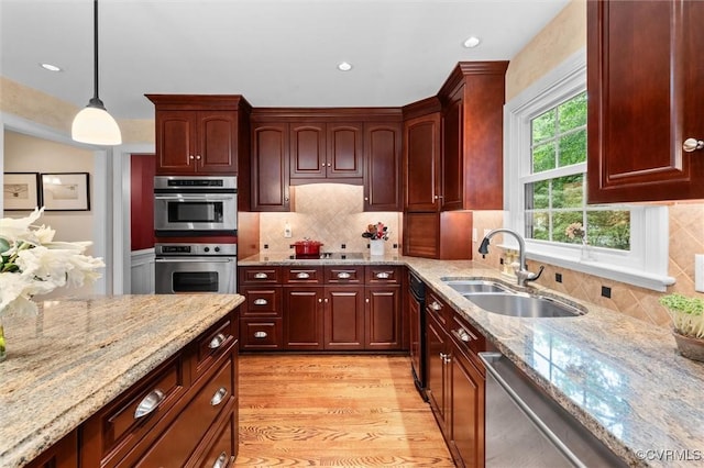 5911 Waters Edge Rd, Midlothian, VA 23112 - kitchen featuring appliances with stainless steel finishes, light wood-type flooring, light stone counters, pendant lighting, and dark brown cabinets