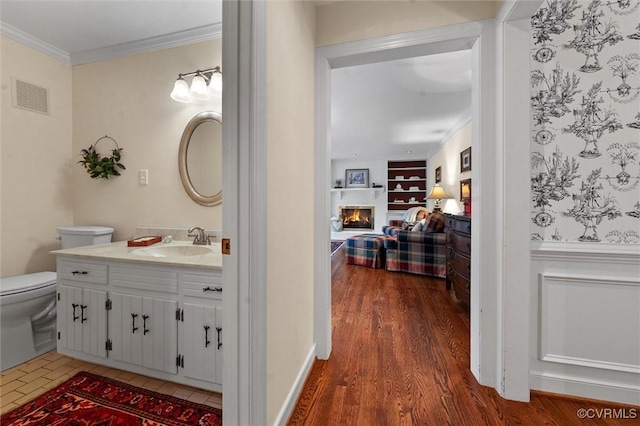 5911 Waters Edge Rd, Midlothian, VA 23112 - bathroom with vanity, built in shelves, a lit fireplace, ornamental molding, and wood finished floors
