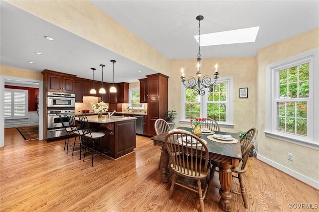5911 Waters Edge Rd, Midlothian, VA 23112 - dining area featuring a chandelier, light wood-type flooring, and a skylight