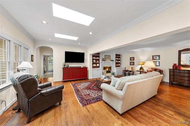 5911 Waters Edge Rd, Midlothian, VA 23112 - living room with arched walkways, light wood finished floors, crown molding, recessed lighting, and a skylight