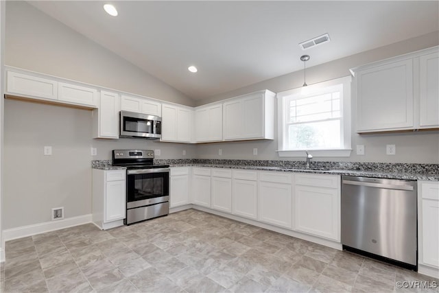 68 Halls Store Rd, Mineral, VA 23117 - kitchen featuring appliances with stainless steel finishes, vaulted ceiling, dark stone countertops, white cabinetry, and pendant lighting