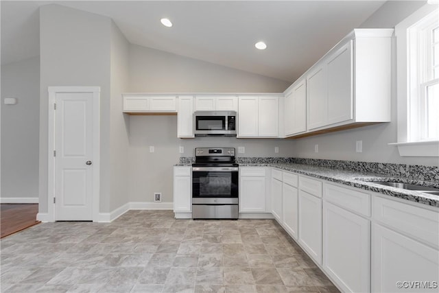 68 Halls Store Rd, Mineral, VA 23117 - kitchen featuring stainless steel appliances, vaulted ceiling, white cabinets, light stone counters, and recessed lighting