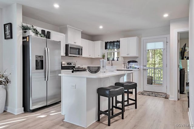 5812 Addison Gate Dr, North Chesterfield, VA 23234 - kitchen featuring appliances with stainless steel finishes, light wood finished floors, white cabinetry, a kitchen bar, and recessed lighting