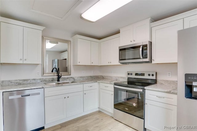 7 Cathy Dr, Newport News, VA 23608 - kitchen featuring stainless steel appliances, white cabinetry, light wood finished floors, and light stone countertops