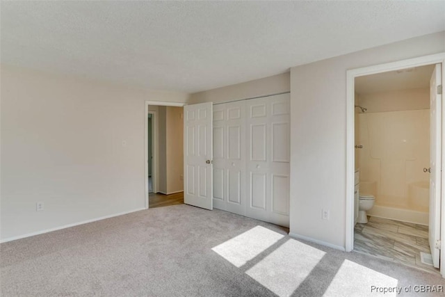7 Cathy Dr, Newport News, VA 23608 - unfurnished bedroom featuring carpet floors, connected bathroom, a textured ceiling, and a closet