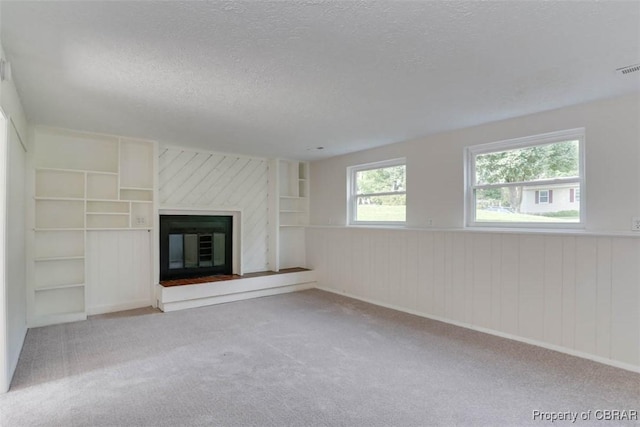 7 Cathy Dr, Newport News, VA 23608 - unfurnished living room with a textured ceiling, carpet flooring, a glass covered fireplace, and wainscoting