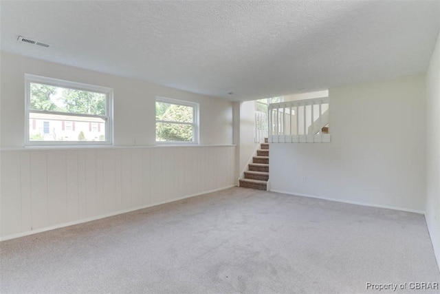 7 Cathy Dr, Newport News, VA 23608 - carpeted empty room with stairs, a textured ceiling, a wainscoted wall, and wooden walls