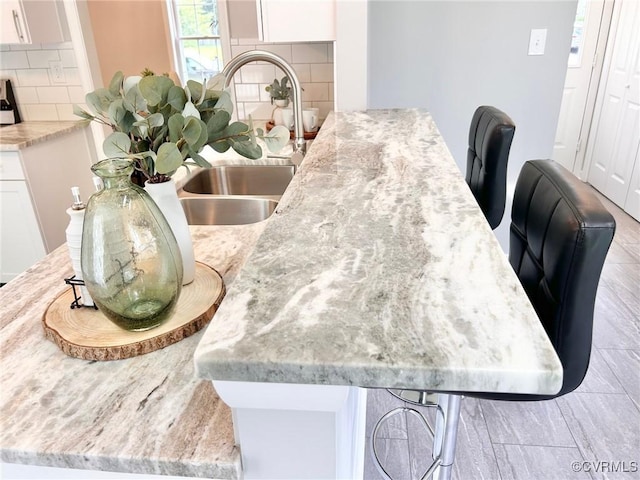 11809 Park Forest Ct, Henrico, VA 23059 - detailed view of decorative backsplash, white cabinetry, and light stone countertops