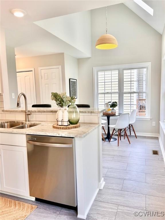 11809 Park Forest Ct, Henrico, VA 23059 - kitchen with stainless steel dishwasher, white cabinetry, decorative light fixtures, light stone counters, and a skylight