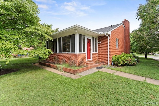 2301 Essex Rd, Henrico, VA 23228 - view of front of home featuring brick siding, a chimney, entry steps, a front lawn, and a sunroom