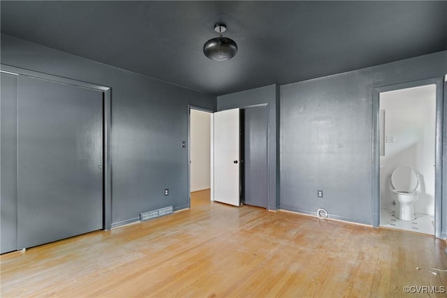 2301 Essex Rd, Henrico, VA 23228 - unfurnished bedroom featuring wood finished floors, multiple closets, and ensuite bath