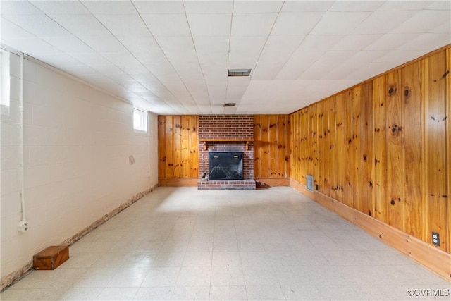 2301 Essex Rd, Henrico, VA 23228 - unfurnished living room featuring a brick fireplace, wood walls, and light flooring