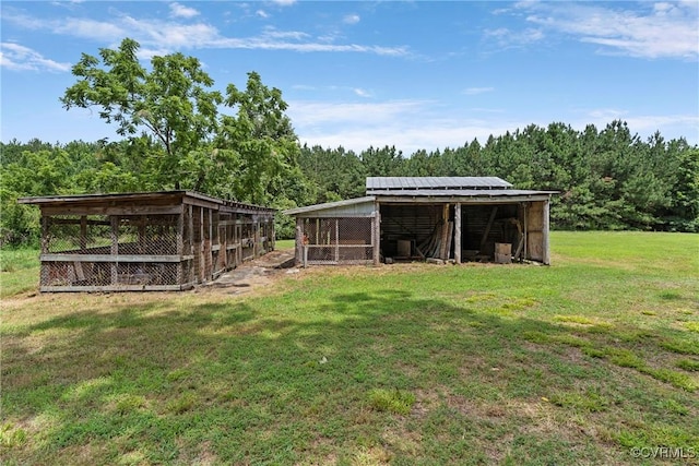 285 Jennings Ordinary Rd, Crewe, VA 23930 - view of green lawn with an outdoor structure, a forest view, and exterior structure