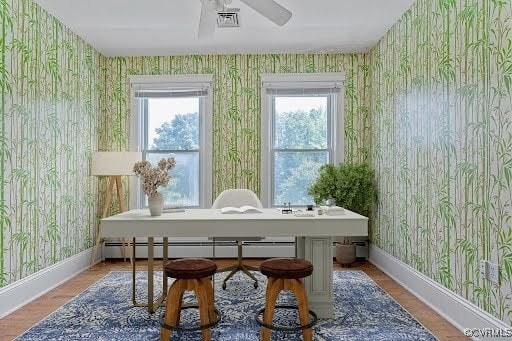 285 Jennings Ordinary Rd, Crewe, VA 23930 - sitting room featuring wallpapered walls, a baseboard radiator, ceiling fan, a desk, and wood finished floors